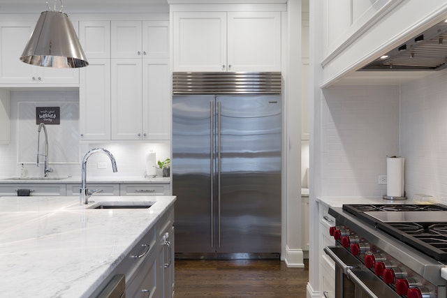 modern kitchen with stainless steel appliances and white marble counters