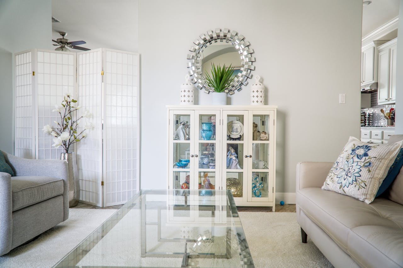 living room with white walls couches round mirror
