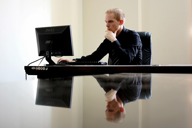 Man pensively examining info on laptop